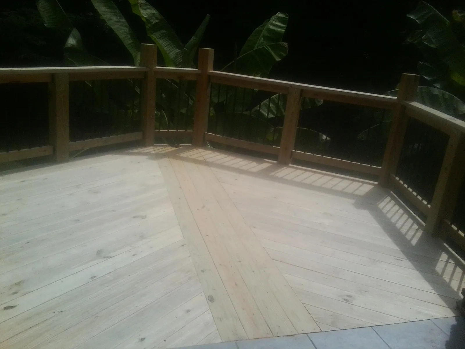 New wood deck and railing built off the back of a home in Phillipsport