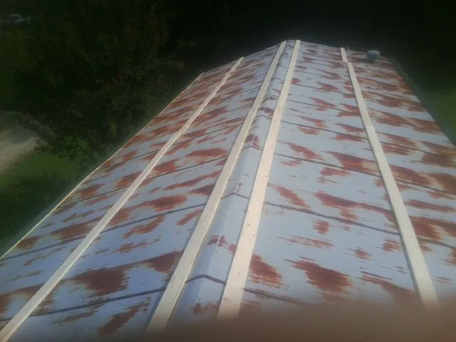 Rusted metal roof panels with new wood purlins before replacement — Storm Damage Roof Repair in Phillipsport by Roofing Brothers