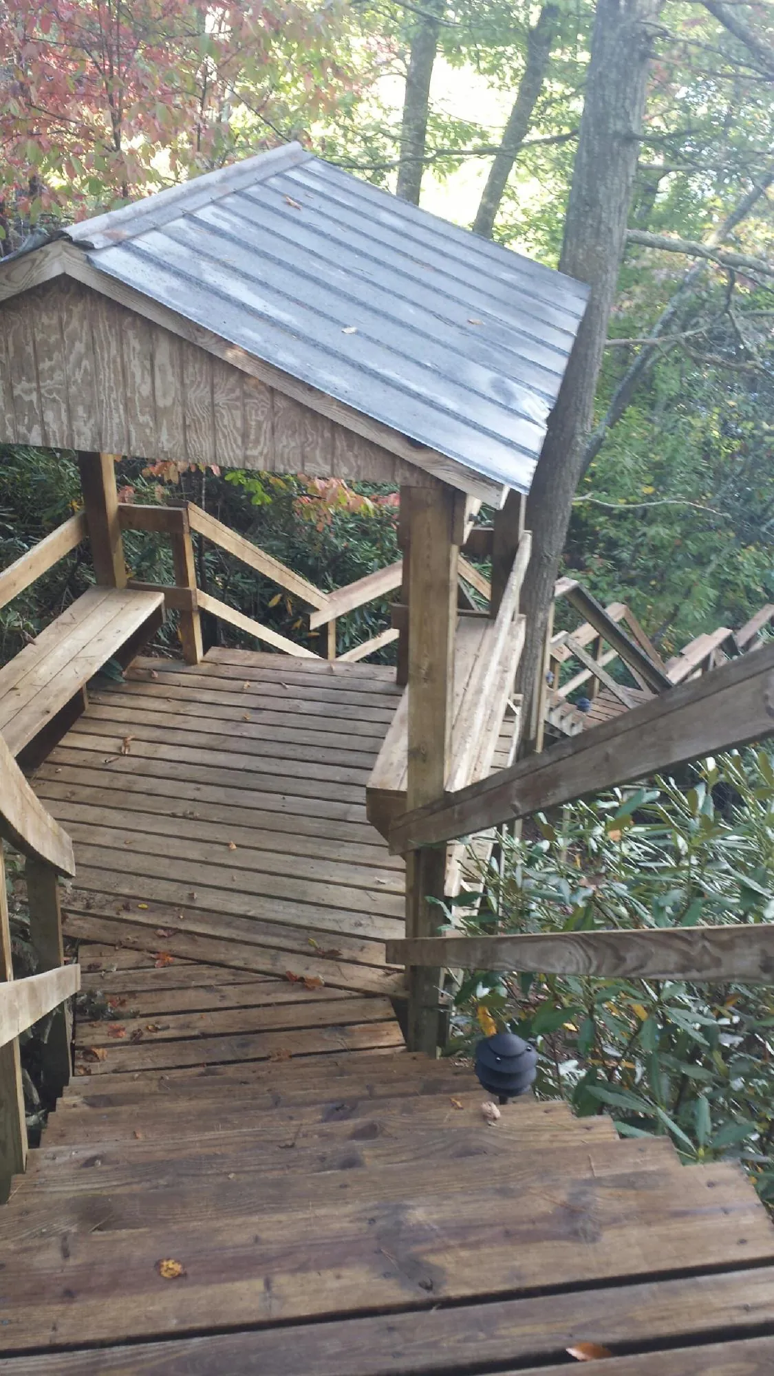 Metal roofed shelter over wooden steps on a wooded walkway — Skylight Repair & Installation work by our crew in Phillipsport
