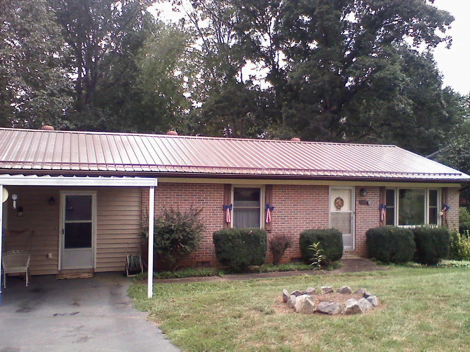 Bronze metal roof and carport on a brick ranch home — Roof Repair work by our crew in Phillipsport